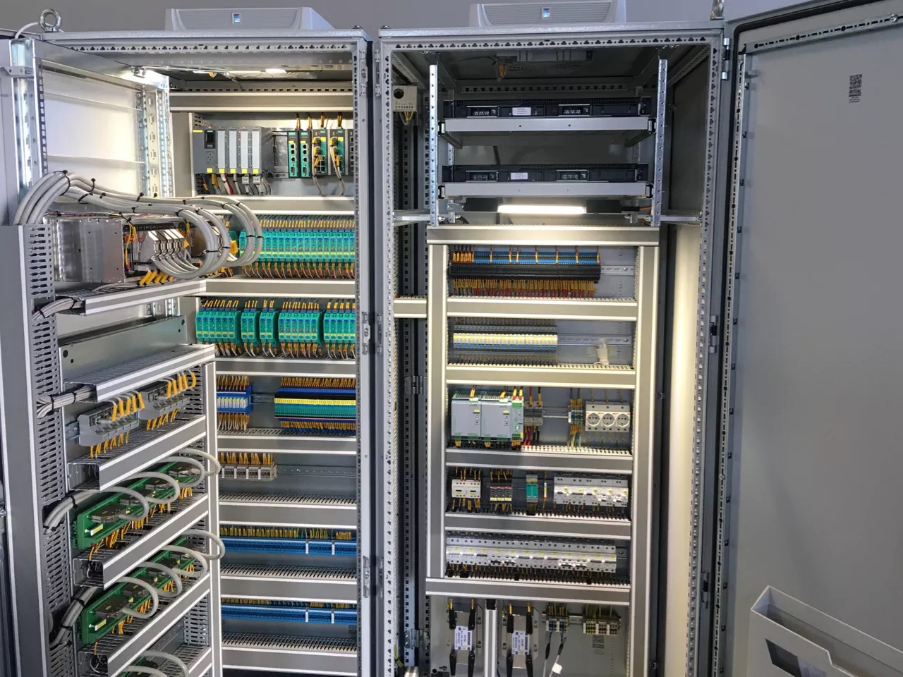 Open control cabinets with controllers, terminal blocks and wiring