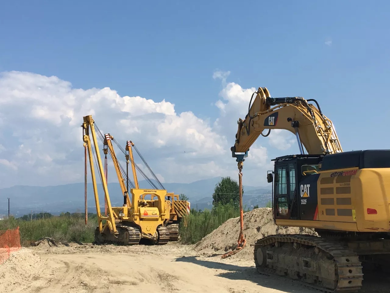 Pipelaying machines and an excavator at work on a pipeline site